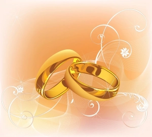 Goldene Hochzeitsringe auf einem Hintergrund mit Blumenmuster